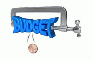 Graphic of budget squeezed in C Clamp and penny falling out