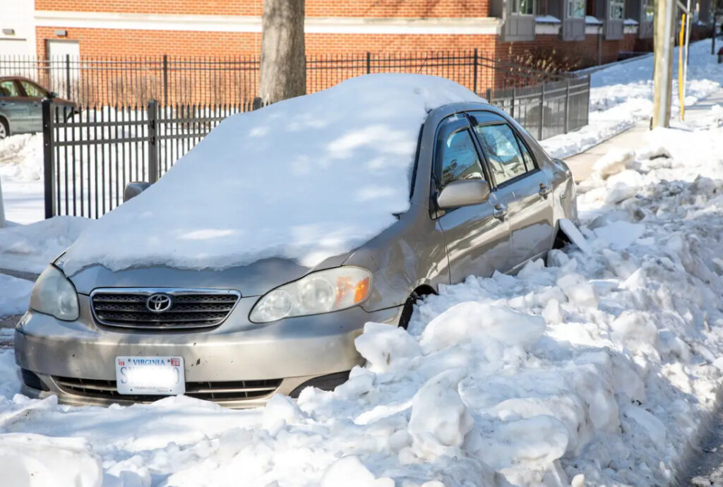 Car barricaded by snow boulders.